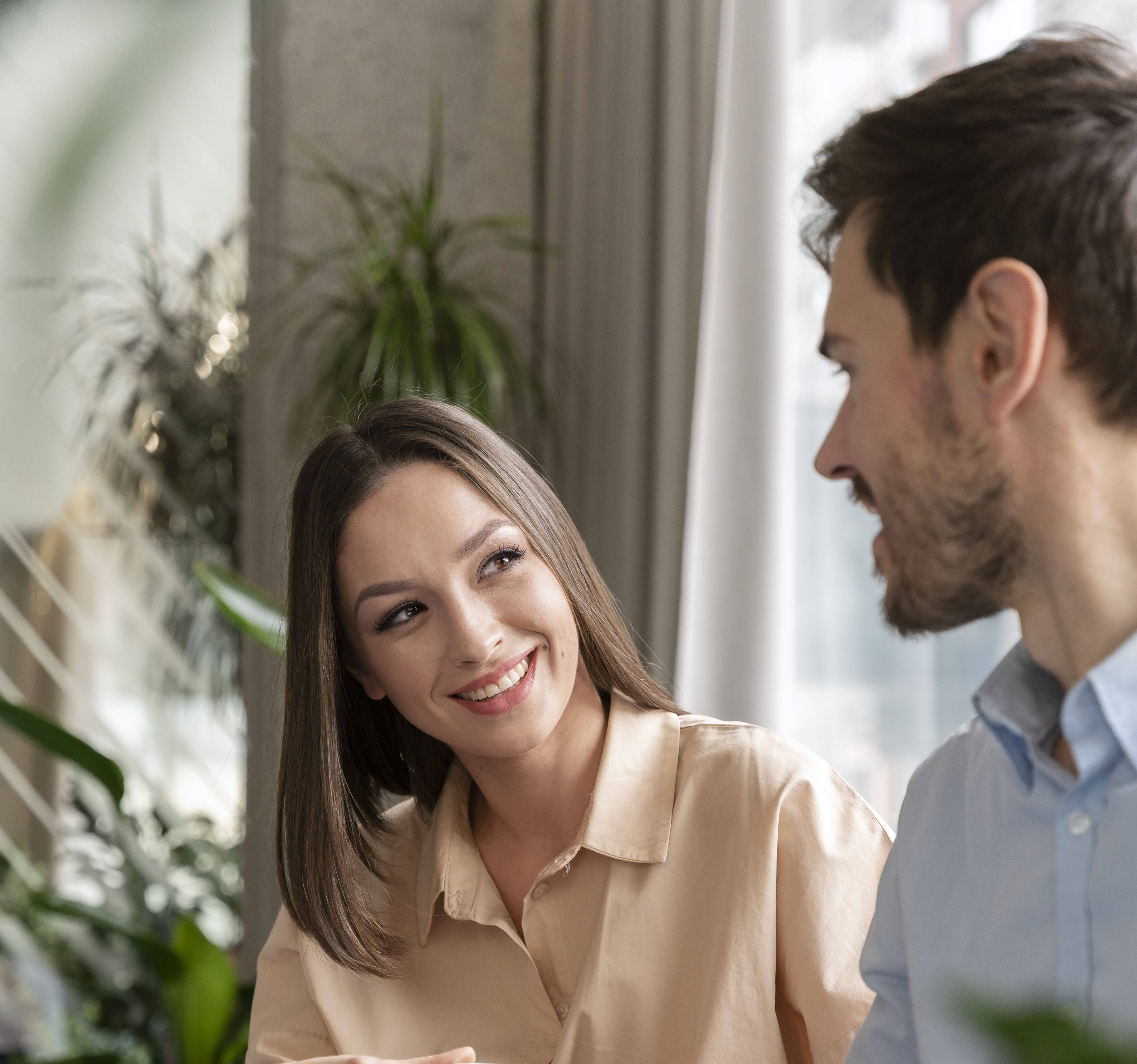 Smiling man and woman working together with a laptop computer.