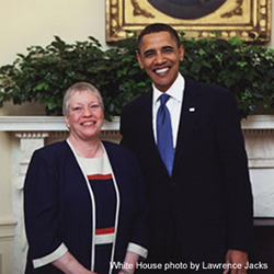 picture of a woman standing beside Barack Obama